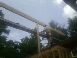 Carpenter setting a ridge beam over a new addition frame — Ice Dam Removal by Roofing Brothers in Mill Hall