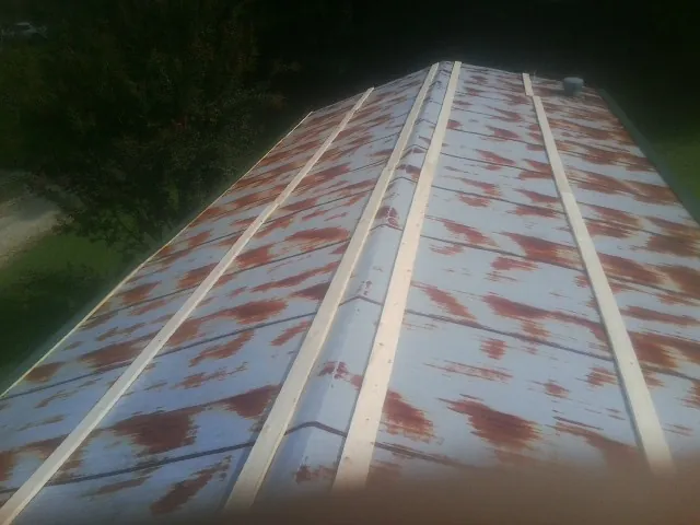 Rusted metal roof panels with new wood purlins before replacement — Storm Damage Roof Repair in Mill Hall by Roofing Brothers