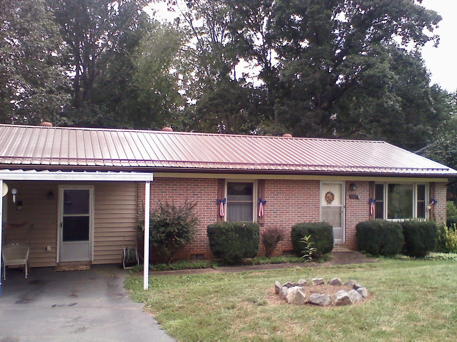 Bronze metal roof and carport on a brick ranch home — Roof Repair work by our crew in Mill Hall